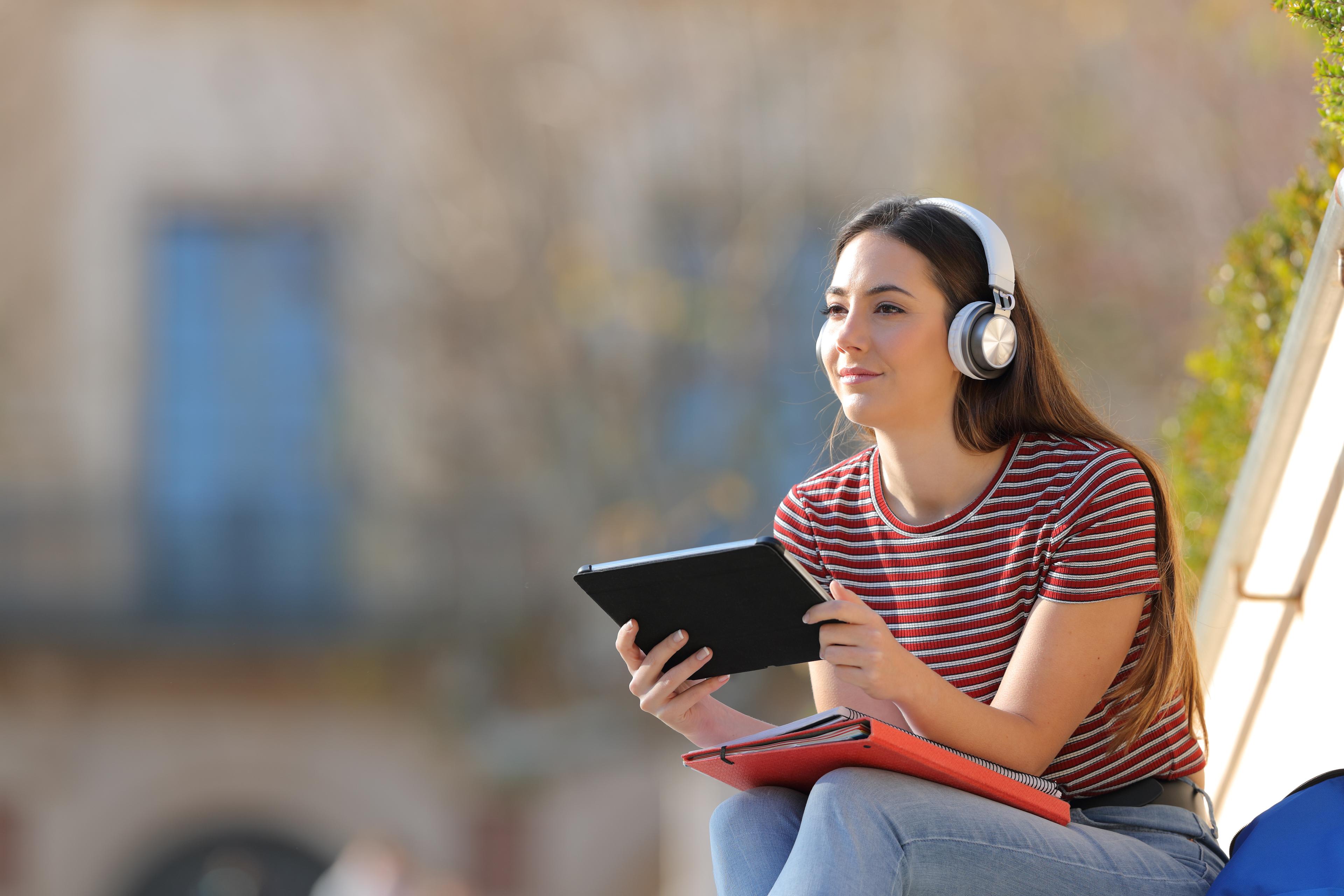 A student with a tablet device and headphones